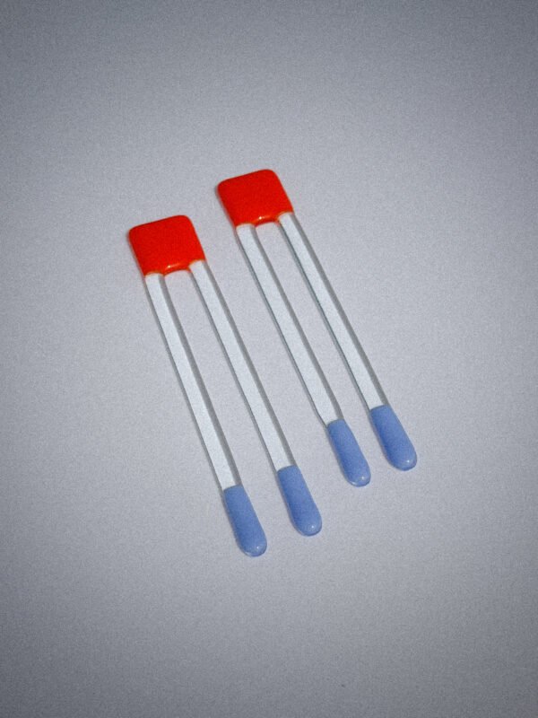 Handgemaakte glazen Pool Sticks in oranje en blauw op een witte tafel.