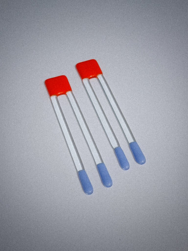 Handgemaakte glazen Pool Sticks in oranje en blauw op een witte tafel.